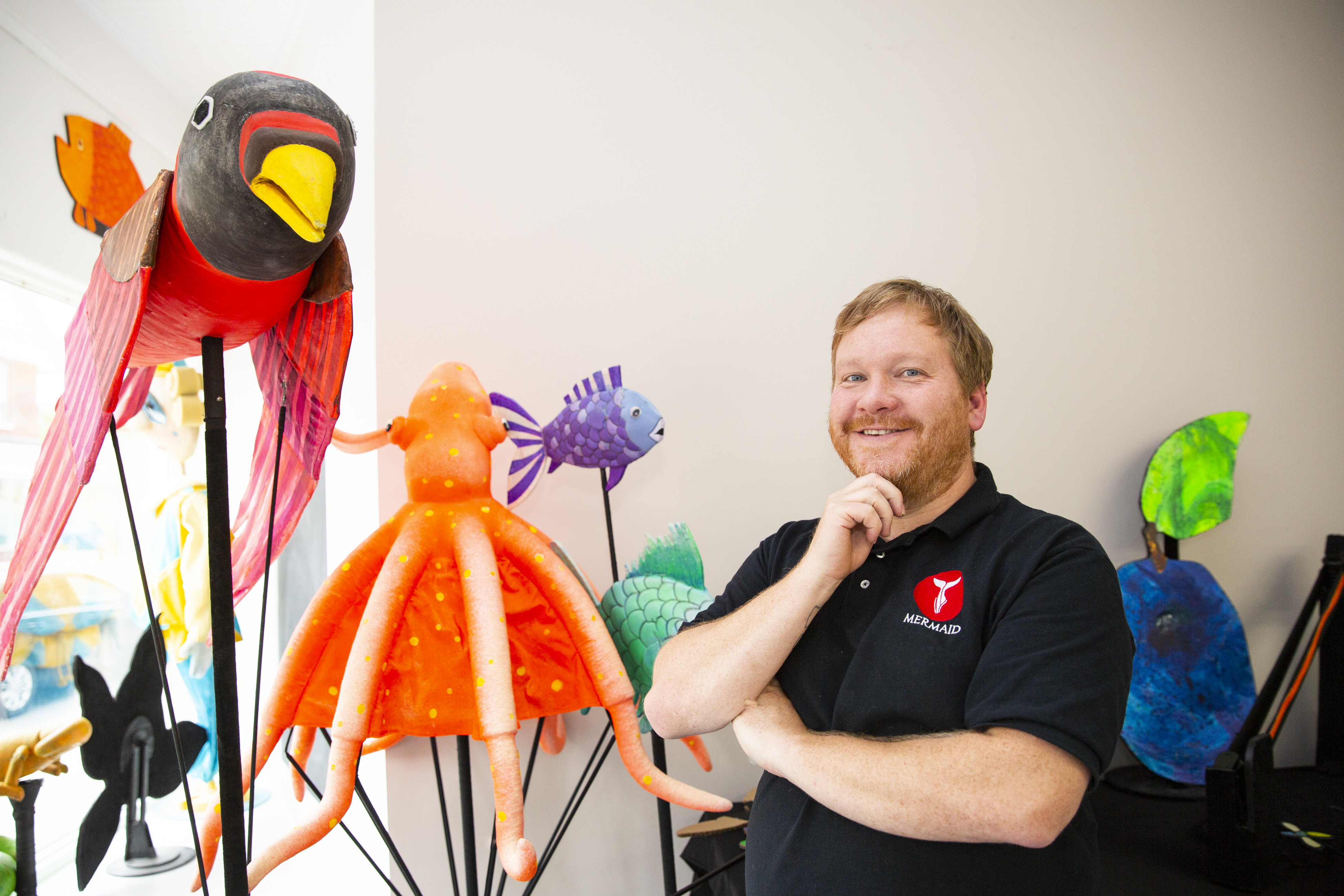 puppeteer Straun Robertson smiles with puppets.